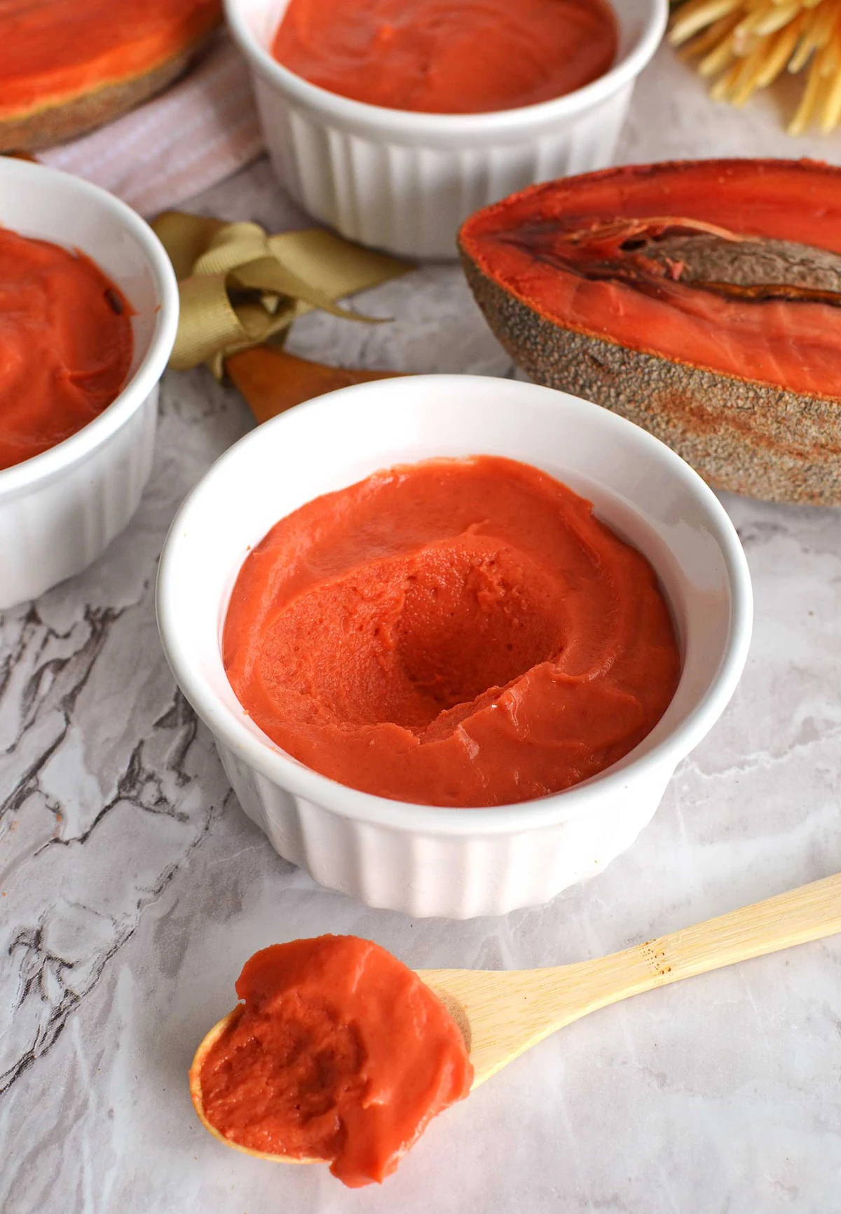 Mamey Zapote pulp in white bowls beside a halved mamey